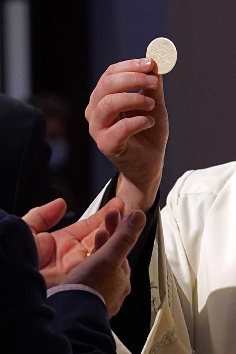 A priest gives the Eucharist to a communicant during a Mass at St. Agnes Cathedral in Rockville Centre, New York, in 2020. (CNS/Gregory A. Shemitz)