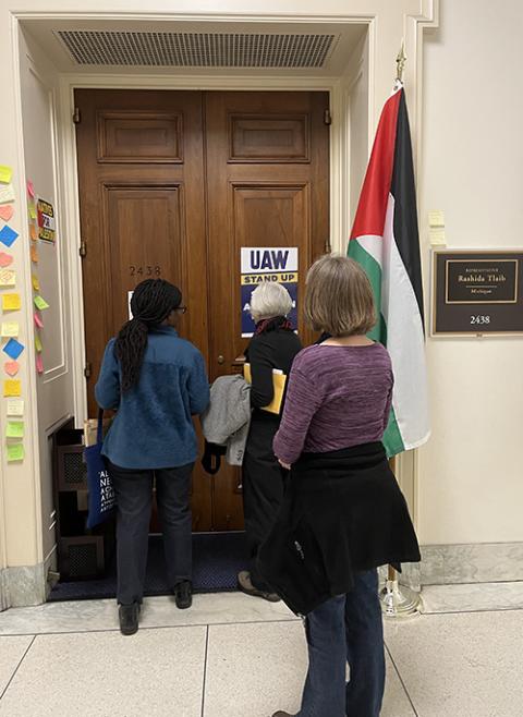 Maryknoll Sr. Susan Nchubiri, Judith Kelly and Kirstin De Mello knock on the door of Rep. Rashida Tlaib's office to deliver a chain of paper cranes on Nov. 9 (NCR photo/Aleja Hertzler-McCain)