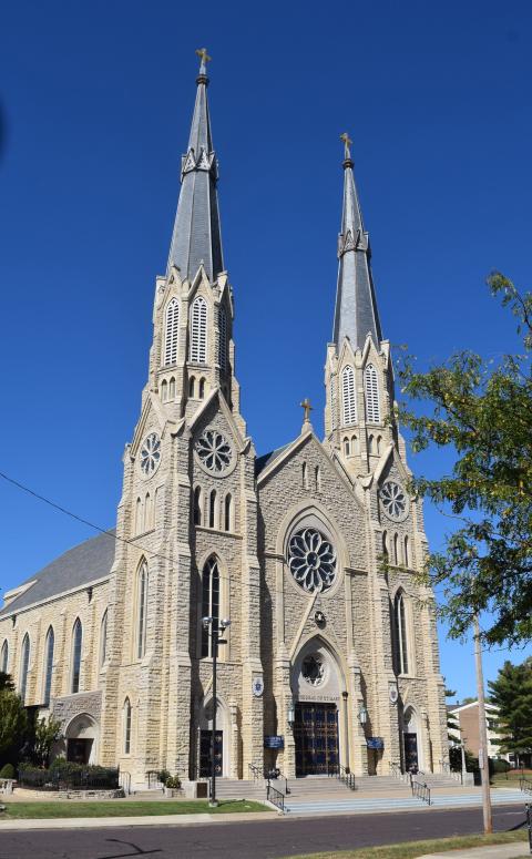 Large gothic facade looms against blue sky. 