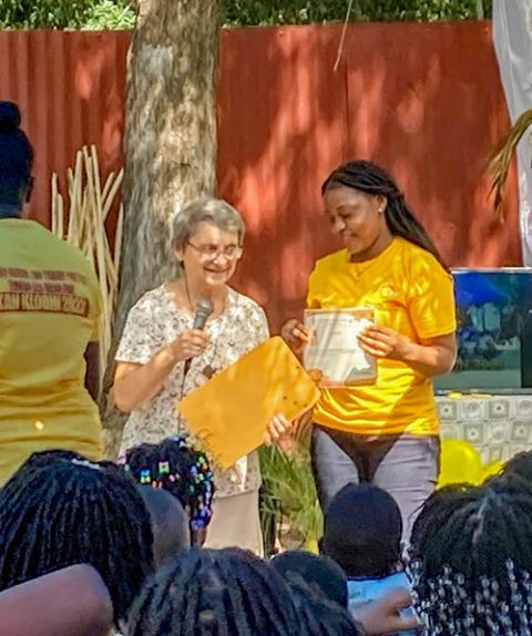 Sr. Jacqueline Picard, with microphone, gives a certificate to a counselor at a summer camp created by sisters of the Religious of Jesus and Mary in Haiti. (Patricia Dillon)