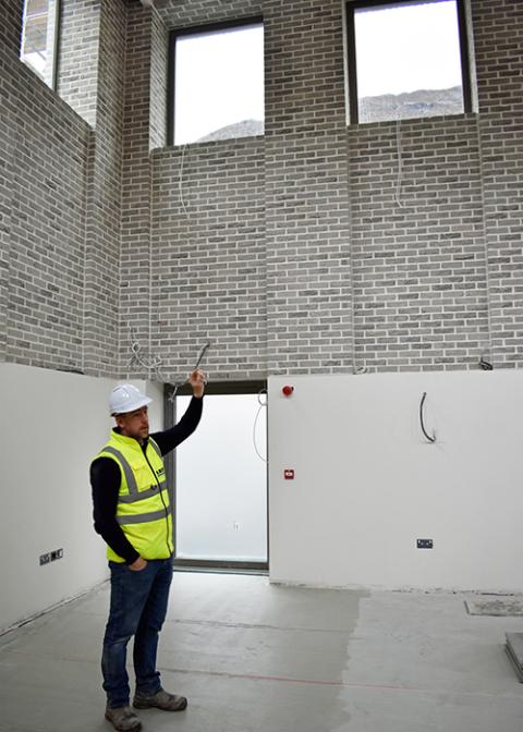 David Connor, Carey Building Contractor’s site manager on the Kylemore monastery project, explains the intricate brickwork around the high windows created for the multipurpose room. (Julie A. Ferraro)