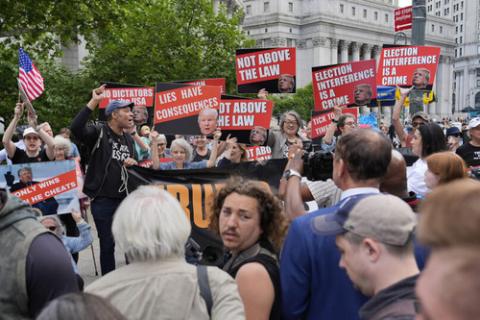 People hold signs outside of courthouse