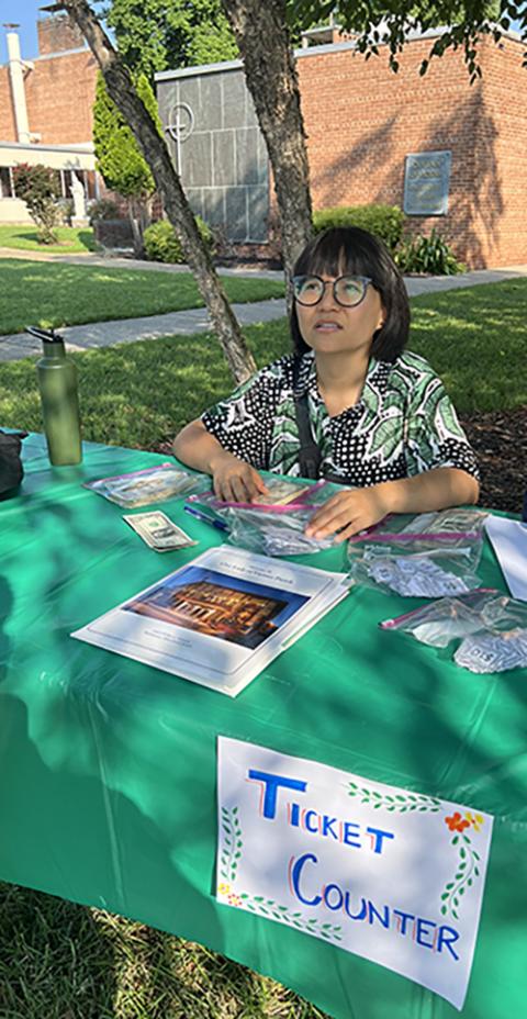 Joan Huai welcomes guests at the first Burmese food fair at Our Lady of Victory parish in Baltimore. Huai and her fellow Burmese parishioners, many of them refugees, helped save the parish this year and have started a 3,000-square-foot community garden there. (Matt Palmer)