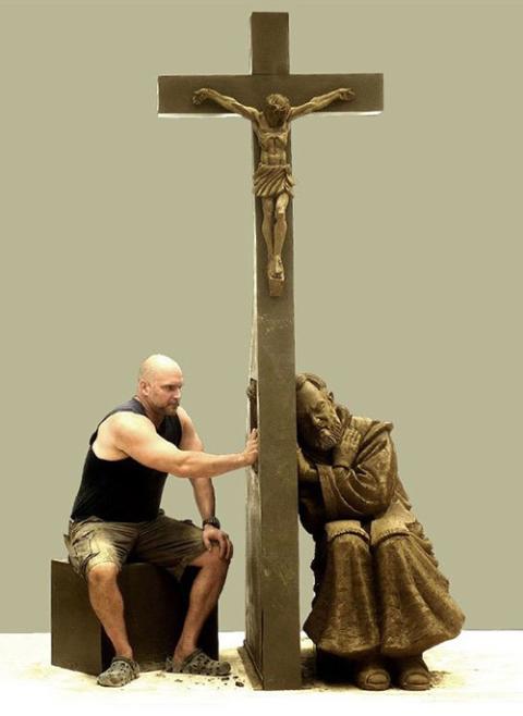 Tim Schmalz engaging with "Absolve," his reconciliation sculpture featuring Padre Pio (Courtesy of Tim Schmalz)