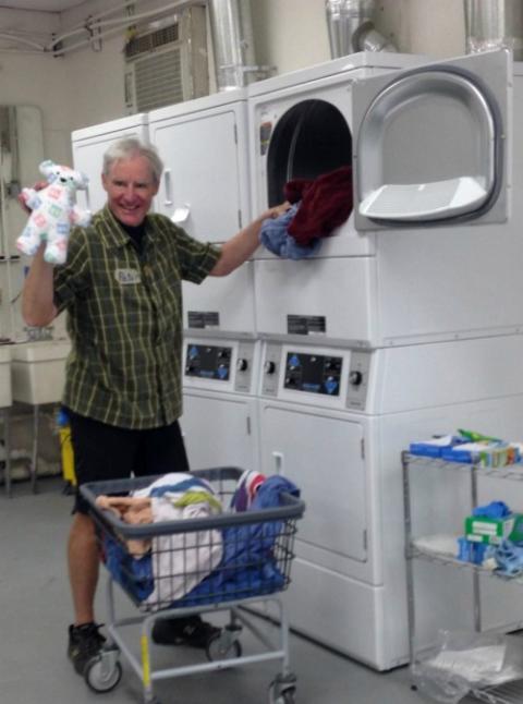 Peter Wise, a volunteer from the San Francisco Bay Area, helped with the essential behind-the-scenes work at Annunciation House in El Paso, Texas: washing tons of bedding, clothing and, occasionally, a stuffed animal. (Petrina Grube)