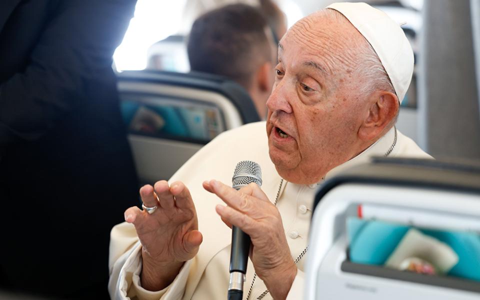 Pope Francis answers a question from a journalist aboard his flight back to Rome Sept. 29, after visiting Luxembourg and Belgium during his 46th international trip. (CNS/Lola Gomez)