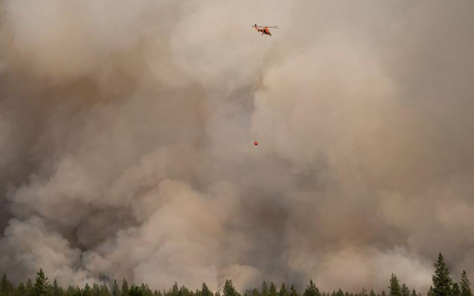 A helicopter in Nespelem, Wash., prepares to drop water on the Chuweah Creek Fire July 14, 2021. The Northwest United States experienced record-breaking high temperatures from late June through mid-July 2021. (CNS/Reuters/David Ryder)