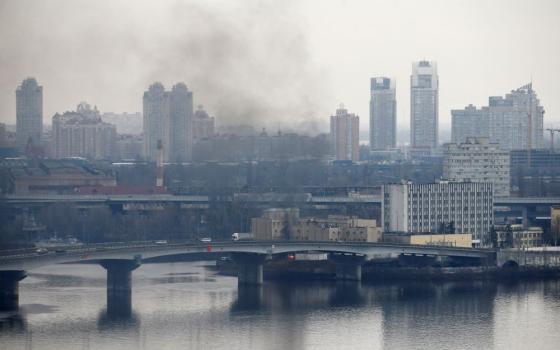 Smoke rises from the territory of the Ukrainian Defense Ministry's unit in Kyiv Feb. 24 after Russian President Vladimir Putin authorized a military operation in Ukraine. (CNS/Reuters/Valentyn Ogirenko)