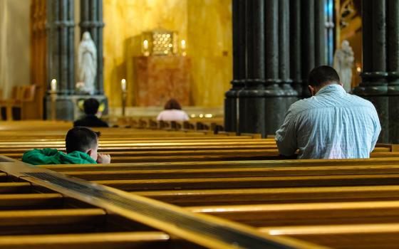 A child watches his father pray inside the Cathedral of Sts. Peter and Paul in Providence, Rhode Island. (CNS/Bob Mullen)