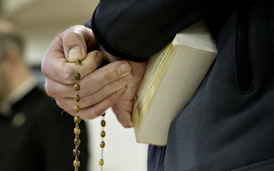 A seminarian from St. John's Seminary in Brighton, Massachusetts, holds a rosary before a discussion with a youth group in 2016. (CNS/Chaz Muth)