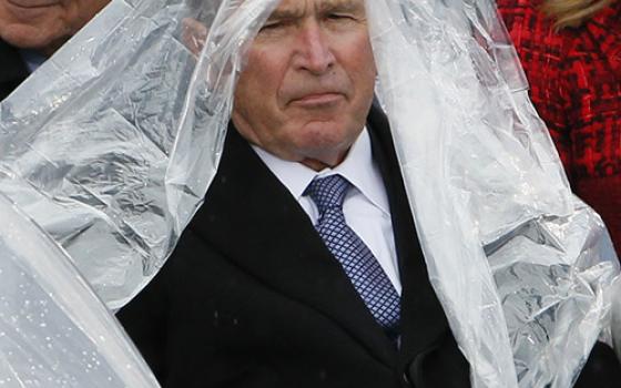 Former President George W. Bush keeps covered in the rain during Donald Trump's presidential inauguration Jan. 20, 2017, at the U.S. Capitol in Washington. (CNS/Reuters/Rick Wilking)