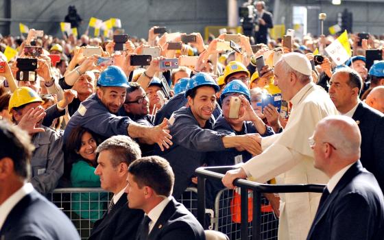 Pope Francis greets workers as he arrives at the ILVA steel plant during a May 2017 pastoral visit in Genoa, Italy. (CNS/Reuters/Giorgio Perottino)