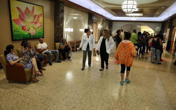 Medical staff and others walk through the hallway of Mutual Help Catholic Hospital in San Juan, Puerto Rico, in 2017. (CNS/Bob Roller)