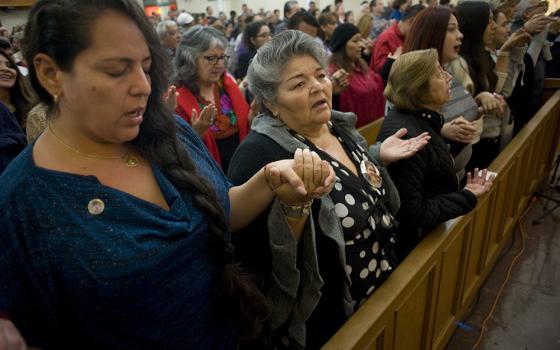 Worshippers recite the Lord's Prayer during a Mass celebrated in honor of the 100th anniversary of Our Lady of Guadalupe Church Dec. 9, 2017, in San Diego. The church was first founded to serve the recently arrived Mexican population in San Diego, and has