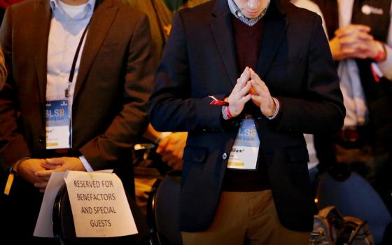 A sign for reserved seating is seen as young people pray during the closing Mass Jan. 6 for the Student Leadership Summit sponsored by the Fellowship of Catholic University Students in Chicago. (CNS/Chicago Catholic/Karen Callaway)