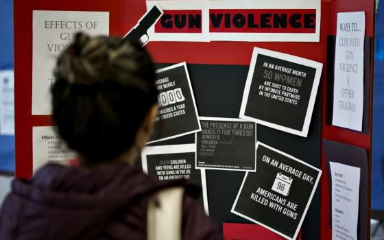 A person reads information about gun violence during a panel discussion about gun policy analysis and citizen activism at Trinity Washington University March 23. (CNS/Tyler Orsburn)