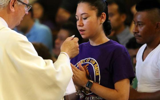 A participant receives Communion during Mass at Immaculate Conception Seminary in Huntington, New York, Sept. 3, 2018, during the Rockville Centre Diocese's annual Labor Day Encuentro gathering for Latino youth and young adults. (CNS/Long Island Catholic)