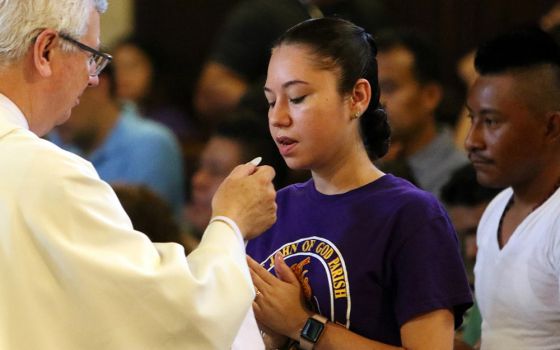 A participant receives Communion during Mass at Immaculate Conception Seminary in Huntington, New York, Sept. 3, 2018, during the Rockville Centre Diocese's annual Labor Day Encuentro gathering for Latino youth and young adults. (CNS/Long Island Catholic)