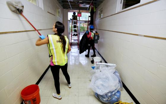 Restoration workers clean a hallway inside St. Mary School Sept. 28 in Wilmington, North Carolina, which sustained significant damage from Hurricane Florence. (CNS/Bob Roller)