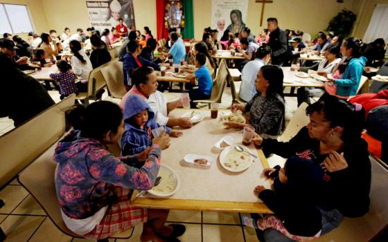 Migrants eat at a Catholic-run shelter in Ciudad Juárez, Mexico, May 10 (CNS/Reuters/Jose Luis Gonzalez)