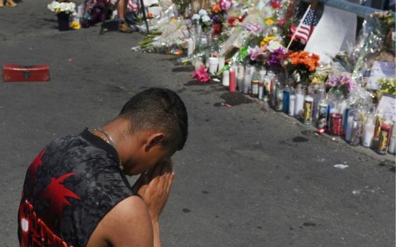 A man prays at a memorial Aug. 6, three days after a mass shooting at a Walmart store in El Paso, Texas. (CNS/Reuters/Callaghan O'Hare)