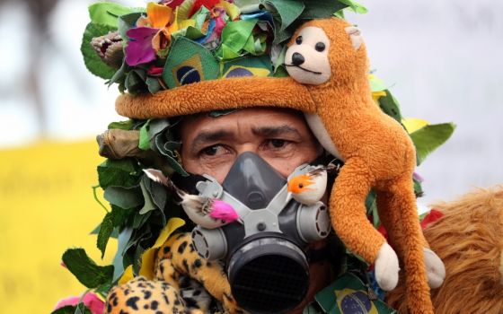 An Amazon rainforest advocate is seen wearing a gas mask in Rio de Janeiro Aug. 25. (CNS/Reuters/Sergio Moraes)