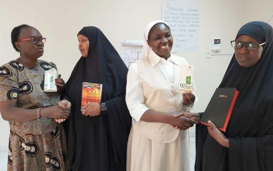 A Catholic woman and nun exchange holy books with Muslim women leaders Dec. 13, 2019, in Garissa, Kenya. (CNS/Courtesy of Fr. Nicholas Mutua)