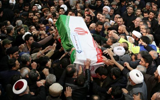 Mourners touch the casket of Iranian Maj. Gen. Qassem Soleimani during his funeral procession in Tehran Jan. 6. The military leader was killed Jan. 3 in a U.S. drone airstrike at Baghdad International Airport. (CNS/Khamenei website handout via Reuters)