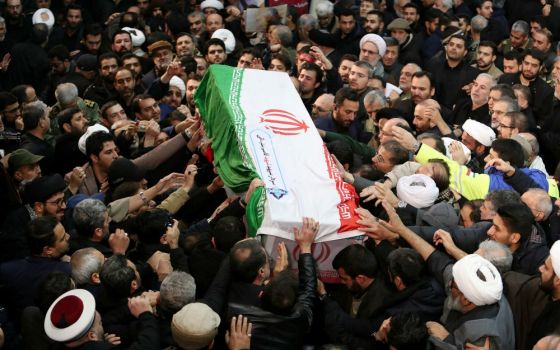 Mourners touch the casket of Iranian Maj. Gen. Qassem Soleimani during his funeral procession in Tehran Jan. 6. The military leader was killed Jan. 3 in a U.S. drone airstrike at Baghdad International Airport. (CNS/Khamenei website handout via Reuters)