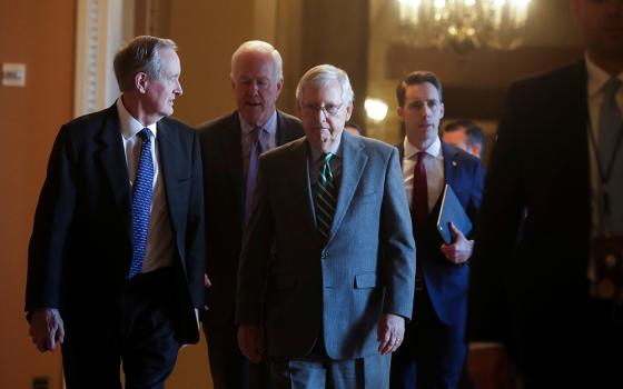 U.S. Senate Majority Leader Mitch McConnell, R-Ky., center, arrives with fellow Republican senators prior to the Senate receiving the House impeachment managers Jan. 16, and the procedural start of the impeachment trial of President Donald Trump at the U.