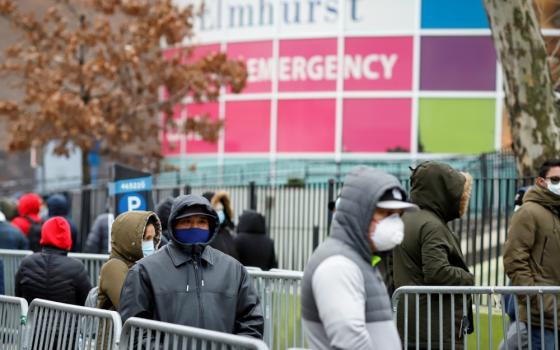 People wearing protective gear wait in line to be tested for the coronavirus (COVID-19) outside Elmhurst Hospital Center in the Queens borough of New York City March 25. (CNS/Reuters/Stefan Jeremiah)