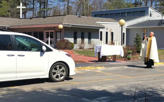 Fr. Lou Phillips, pastor of Our Lady of Perpetual Help Parish in Windham, Maine, holds the Blessed Sacrament April 19 during a "drive-thru" Divine Mercy Sunday blessing in the church parking lot, amid the coronavirus pandemic. (CNS)