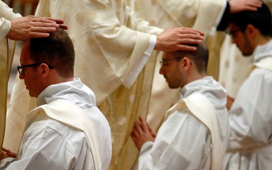 Priests put their hands on the heads of newly ordained priests during an ordination Mass celebrated by Pope Francis May 12, 2019, in St. Peter's Basilica at the Vatican. (CNS/Reuters/Yara Nardi)