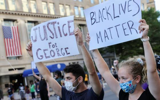 Demonstrators hold placards during a protest in Washington June 1. (CNS/Reuters/Jonathan Ernst)