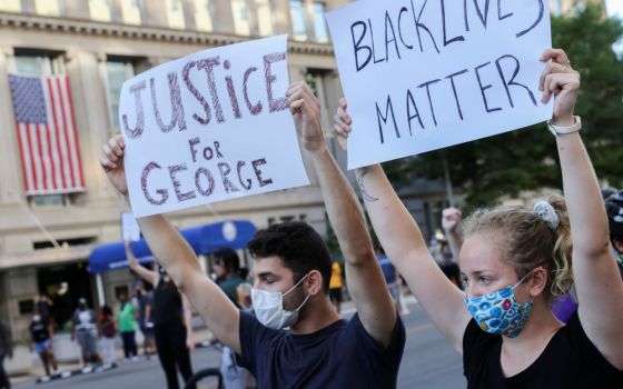 Demonstrators hold placards during a protest in Washington June 1. (CNS/Reuters/Jonathan Ernst)