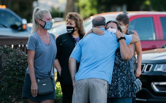 People attend a prayer vigil outside St. Joseph Catholic Church in Trenton, Michigan, Aug. 17, for Robert Chiles, a parishioner, and Fr. Stephen Rooney, St. Joseph's pastor, who disappeared in a boating accident on the Detroit River the previous day.