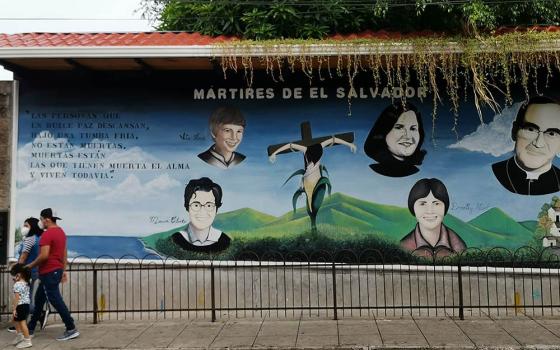 Salvadorans walk past a mural of Salvadoran martyrs Aug. 15, 2020, outside Our Lady of Pilar Catholic Church in Zaragoza, El Salvador. The mural includes St. Óscar Romero and four U.S. churchwomen slain in El Salvador in 1980. (CNS)