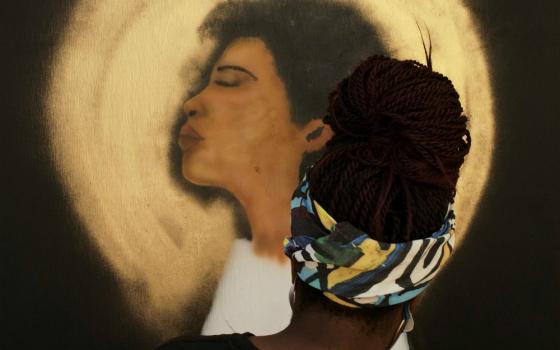 A woman in Washington paints a mural on the boarded-up windows of St. John's Episcopal Church at Black Lives Matter Plaza Sept. 5. (CNS/Reuters/Cheriss May)