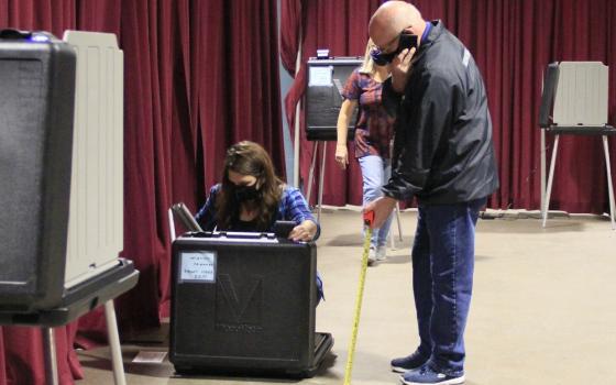 Volunteers in Fort Wayne, Indiana, set up voting machines Oct. 5 for early voting. (CNS/Today’s Catholic/Jodi Marlin)