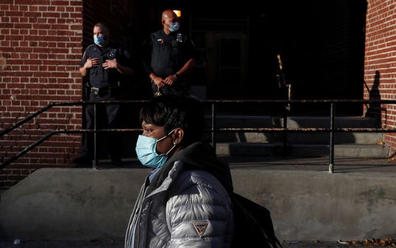 A woman walks past police officers in the Brooklyn borough of New York City Oct. 14, 2020. (CNS/Reuters/Shannon Stapleton)