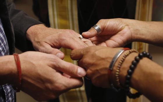 A same-sex couple is pictured in a file photo exchanging rings during a ceremony in Salt Lake City. In a new documentary, Pope Francis expressed openness to the idea of laws recognizing civil unions, including for gay couples, to protect their rights. (CN