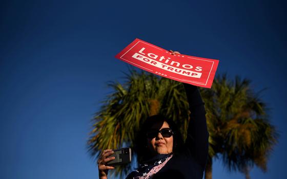 A Latina voter holds up a sign in support of President Donald Trump as voters line up at a polling station on Election Day in Houston Nov. 3. (CNS/Reuters/Callaghan O'Hare)