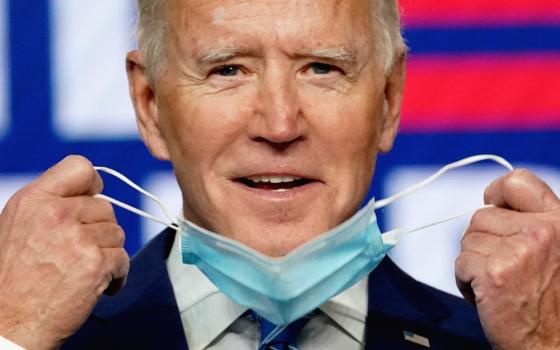 Joe Biden removes his face mask to speak about the presidential election results during an appearance in Wilmington, Delaware, Nov. 4. (CNS/Reuters/Kevin Lamarque)