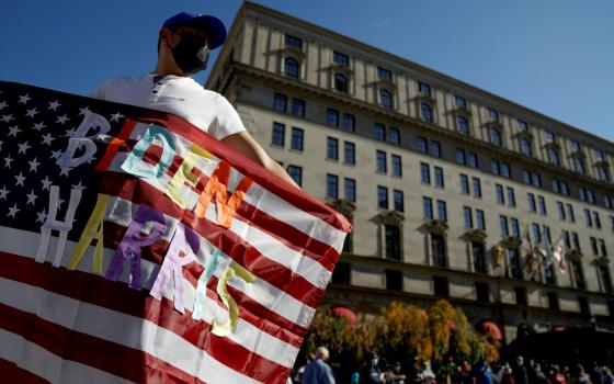 A man in Washington waves an American flag with the words "Biden Harris" near the White House Nov. 8, the day after the news media called the presidential election for Democrat Joe Biden. (CNS/Reuters/Erin Scott)