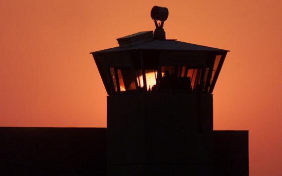 The sun sets behind one of the guard towers in a 2001 file photo at the Federal Correctional Complex in Terre Haute, Indiana, the site where the federal death penalty is carried out. (CNS/Reuters/Andy Clark)