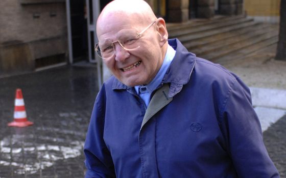 Wearing his trademark blue workman’s uniform, Discalced Carmelite Fr. Reginald Foster is photographed near the Vatican post office in this January 2007 file photo. (CNS/Chris Warde-Jones)