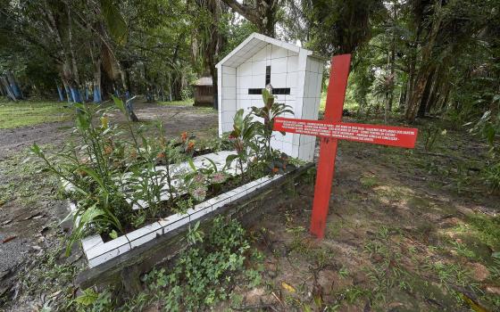 A red cross stands beside the grave of U.S.-born Sister Dorothy Stang in Anapu, Brazil, who was assassinated in 2005. The red cross beside her grave bears the names of 16 local rights activists who have been murdered since her killing. (CNS Photo/Paul Jef