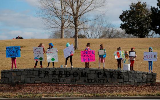 Girl Scouts in Atlanta hold signs urging residents to vote in the runoff election for both of Georgia's U.S. Senate seats Jan. 3. (CNS/Reuters/Brian Snyder)