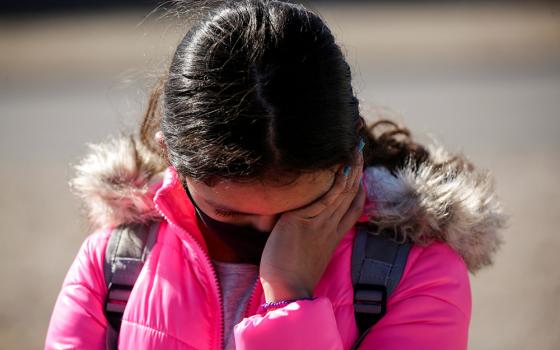 A migrant girl from Central America cries before crossing the Rio Bravo with her family in Ciudad Juárez, Mexico, Feb. 5 to request asylum in El Paso, Texas. (CNS/Reuters/Jose Luis Gonzalez)