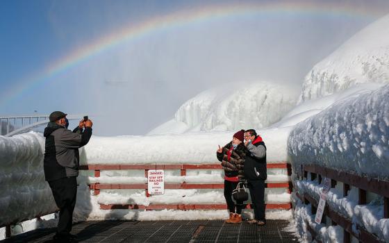 Visitors are photographed at the base of American Falls in Niagara Falls, New York, Feb. 21. (CNS/Reuters/Lindsay DeDario)